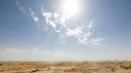 Sky with bright sun and extreme global climate concept. Vast desert landscape under bright sun and clear blue sky.