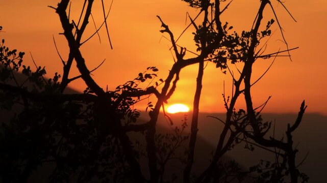 4K cinematic sunset b-roll footage of sun going down behind mountain with cloudy sky from on top of mountain in Nha Trang in Vietnam  