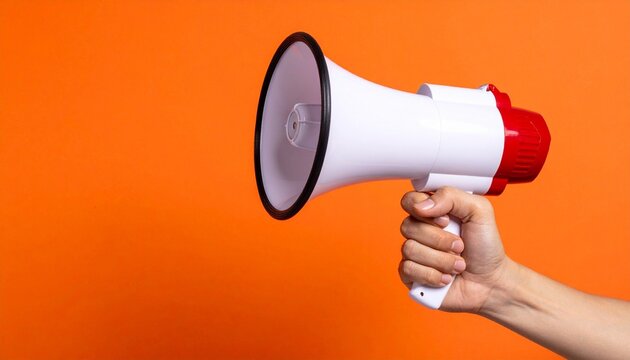 Hand holding megaphone on orange background