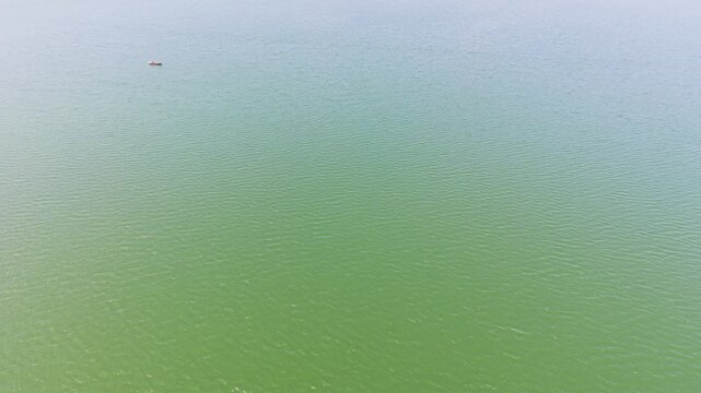 Aerial View Tilt of Small Boat and Small Island in the Trị an Lake.