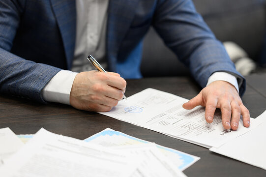 Man signing official contract with stamp on document