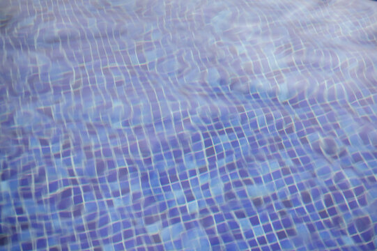 Rippling water over blue-tiled swimming pool surface
