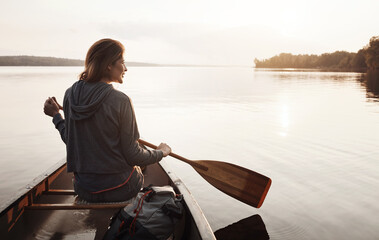 Fototapeta premium Thinking, woman and smile with canoeing on lake for travel adventure, sightseeing nature or space. Sunshine, back of person or rowing boat on water for peaceful tourism, journey reflection or freedom