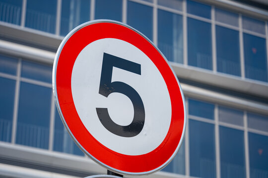 Circular red-bordered white traffic sign indicating speed limit of five kilometers per hour