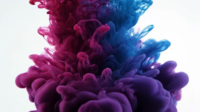 Fluid clouds of red and blue dye mix on white, creating a vibrant abstract shape