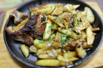 Fried potato with meat on cast iron pan