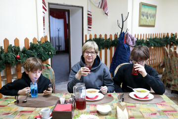Woman and kids sitting at restaurant table with festive decorations