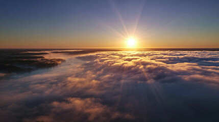 Breathtaking Aerial View of a Sun Rising Above a Sea of Clouds with Majestic Sun Rays