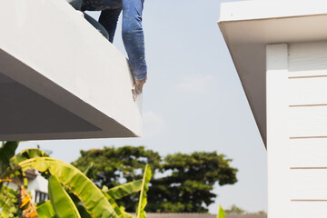 Man sanding roof edge for exterior before painting. © bignai