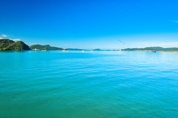 Obraz premium A beautiful view of Langkawi island against a beautiful blue sky with some boats in the distance on the horizon. Tropical scenery. located at Kedah, Malaysia - September 25 2024: