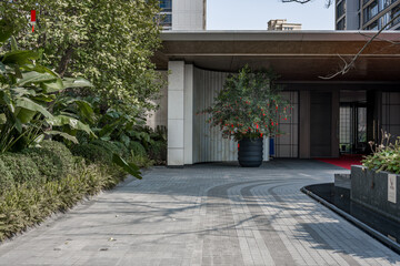 Fototapeta premium Modern architectural entrance with greenery landscape, stone paving, and courtyard design