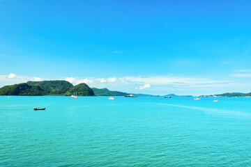 Obraz premium A beautiful view of Langkawi island against a beautiful blue sky with some boats in the distance on the horizon. Tropical scenery. located at Kedah, Malaysia - September 25 2024:
