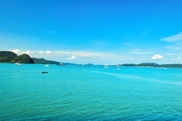 Fototapeta premium A beautiful view of Langkawi island against a beautiful blue sky with some boats in the distance on the horizon. Tropical scenery. located at Kedah, Malaysia - September 25 2024: