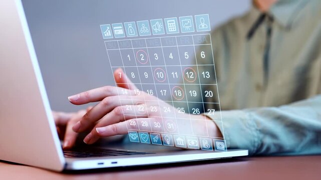 Working with a digital calendar on a laptop in a modern workspace during daytime.
