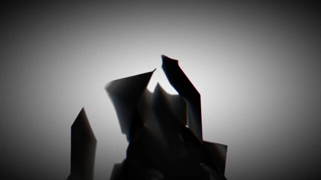 Black geometric shape with angular surfaces positioned near edge of a gradient gray background, creating asymmetry and a striking visual contrast