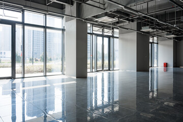 Naklejka premium Modern empty office building lobby with large floor-to-ceiling windows and excellent natural lighting
