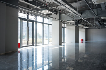 Spacious modern office with floor-to-ceiling windows and high ceiling exposed infrastructure