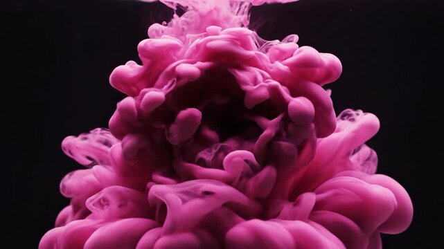 Pink dye swirls and blooms in dark liquid, creating a mesmerizing, organic, and abstract visual
