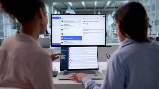 Women Checking Multiple Screens For New Emails