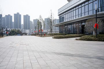 Spacious and clean urban plaza in front of a modern glass building with orderly landscaping