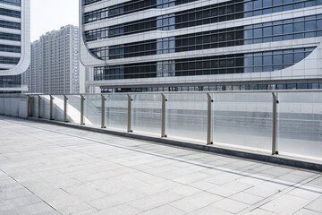 Modern urban elevated walkway with glass railings and high-rise buildings in empty cityscape © zhu difeng