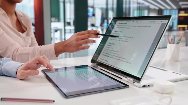 Women Reviewing Business Plan And Conract Documents On Laptop
