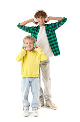 Cute brothers with headphones listening to music on white background