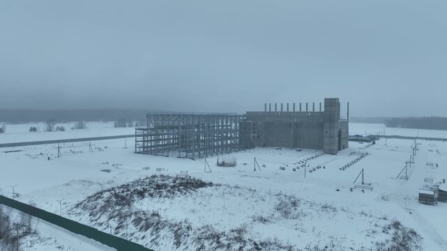 Winter construction zone displays rigid grid of exposed concrete beams. Snow steel and raw geometry form utilitarian visual rhythm