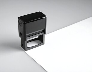 A black ink stamp on a white and gray background
