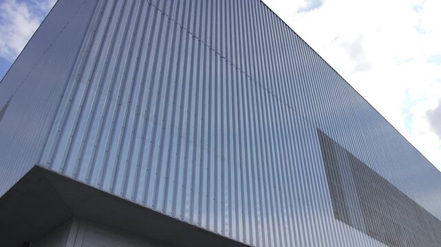 Industrial building clad in corrugated metal displays strict geometry. Muted colors reinforce minimalist character of industrial zone