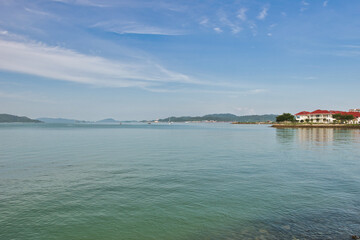 Obraz premium A beautiful view of Langkawi island against a beautiful blue sky with some boats in the distance on the horizon. Tropical scenery. located at Kedah, Malaysia - September 25 2024: