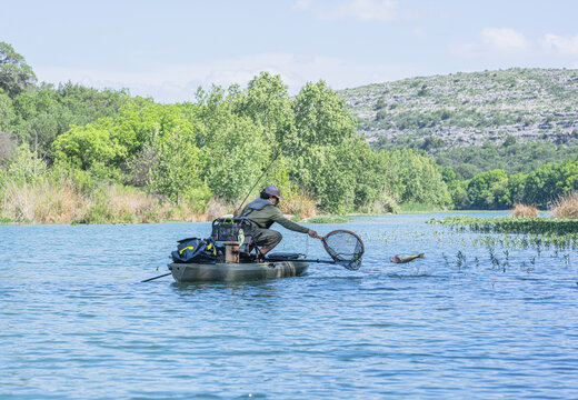 Man attempts to net fish out of kayak