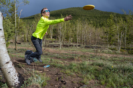 Male Disc Golfer Throwing a Forehand Drive on a Mountain Course