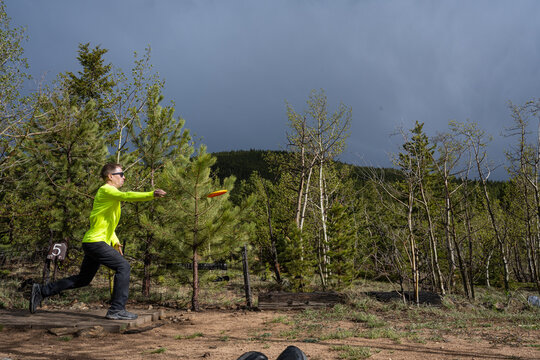 Action Shot of a Male Disc Golfer Launching a Long-Distance Drive