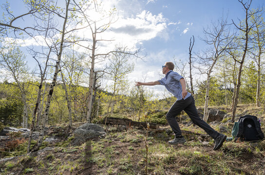 Male Disc Golfer Sinking a Winning Putt into a Metal Chain Basket