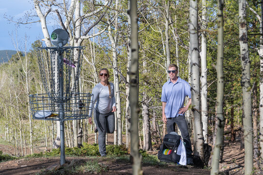 Active Couple Playing Disc Golf in a Scenic Mountain Aspen Grove