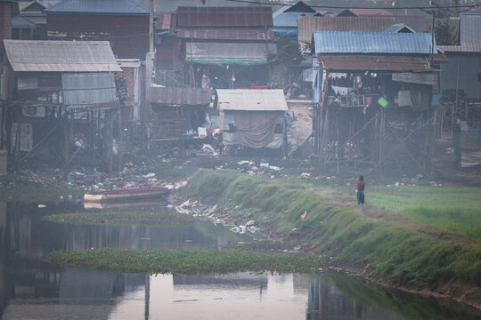 houses and trash next to the lagoon