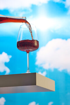 Glass of Red Wine Being Poured Against the Sky