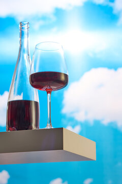 Glass of Red Wine and Bottle Against the Sky