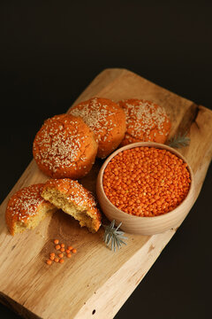 Lentils in a wooden bowl, homemade lentil buns with sesame seeds