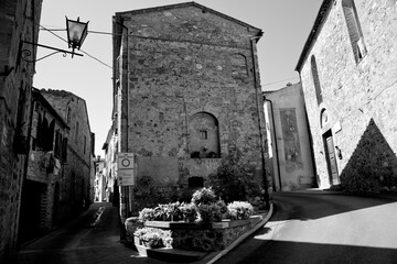 Obraz premium Borghi toscani in bianco e nero. L'architettura medievale dei borghi toscani, caratterizzata da pietra, cotto, riflette il periodo comunale con cinte murarie, torri, vicoli stretti e piazze. Italia. 