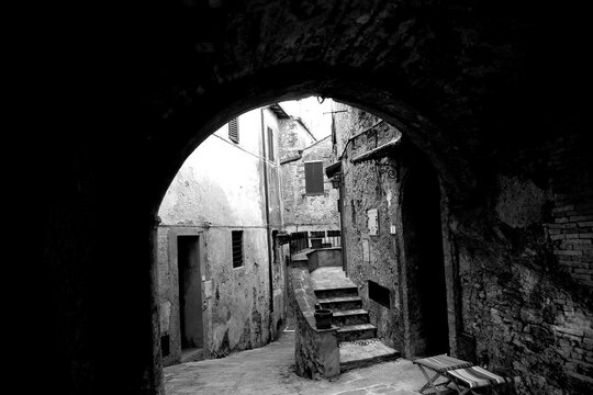 Borghi toscani in bianco e nero. L'architettura medievale dei borghi toscani, caratterizzata da pietra, cotto, riflette il periodo comunale con cinte murarie, torri, vicoli stretti e piazze. Italia. 