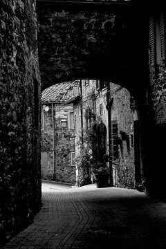 Borghi toscani in bianco e nero. L'architettura medievale dei borghi toscani, caratterizzata da pietra, cotto, riflette il periodo comunale con cinte murarie, torri, vicoli stretti e piazze. Italia. 