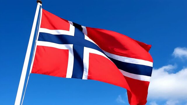 Red, white, and blue flag on a pole against a blue sky with clouds