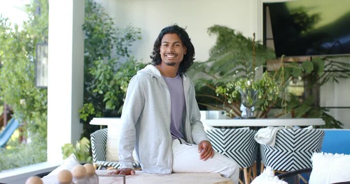 African American man noticing left view, turning and smiling sitting on low table in sunroom