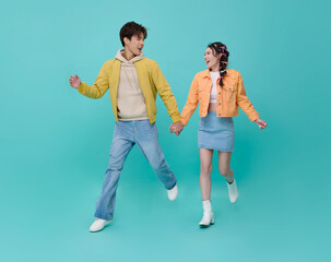 Young couple holding hands running together in playful lifestyle moment expressing love freedom and joyful relationship connection in modern casual fashion.