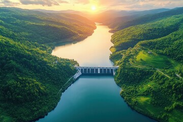 aerial view of a dam holding a tranquil reservoir between lush green hills at sunset with golden light over winding water and forested valleys