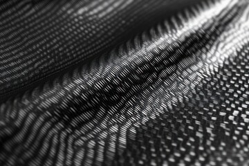 close-up of woven black carbon fiber fabric with reflective diagonal weave creating a dynamic, futuristic, mesmerizing wave texture