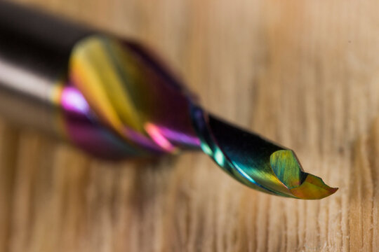 dlc milling cutter with carbide knives. carbon coating. diamond milling cutter for processing aluminum. close-up on a light wooden background. carbide milling cutter. CNC tool. milling cutter knives