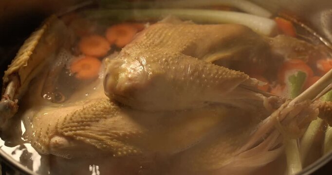 Organic chicken broth is boiling. Homemade chicken broth. Chicken soup.